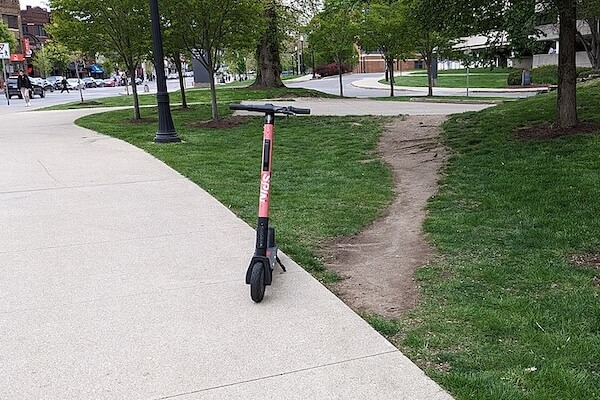 A walking path worn through a patch of grass between concrete sidewalks at Ohio State University